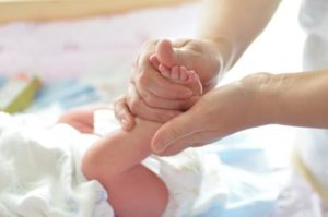 maman appliquant de la crème sur le corps du bébé 