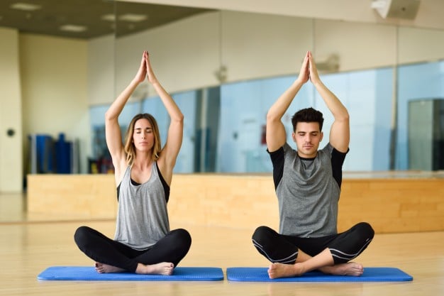 deux personnes pratiquant le yoga